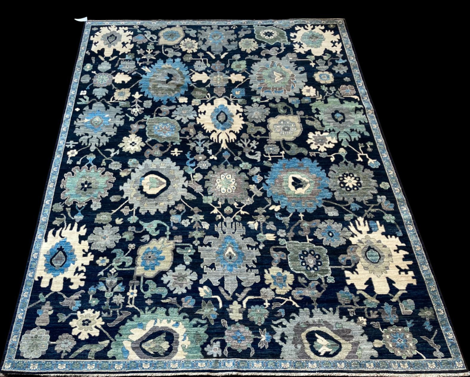 A blue rug with flowers on it on a black background