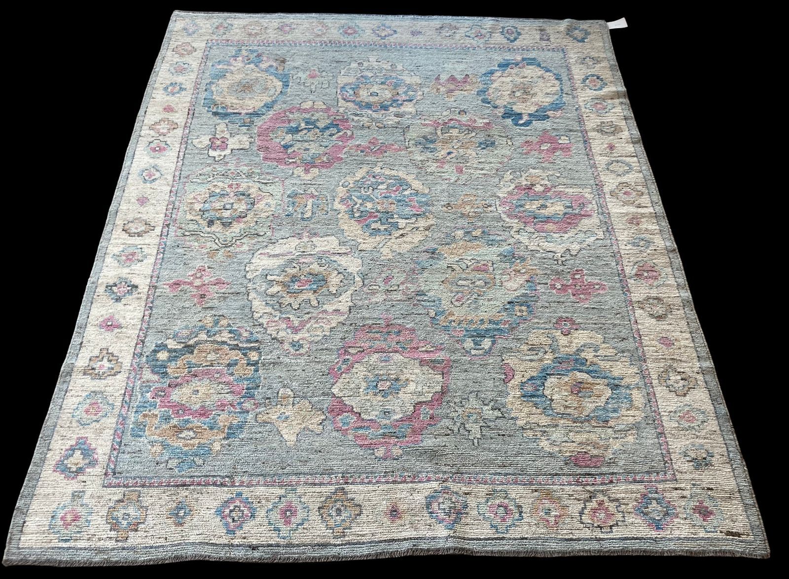 A rug with a floral pattern on it is on a black background.