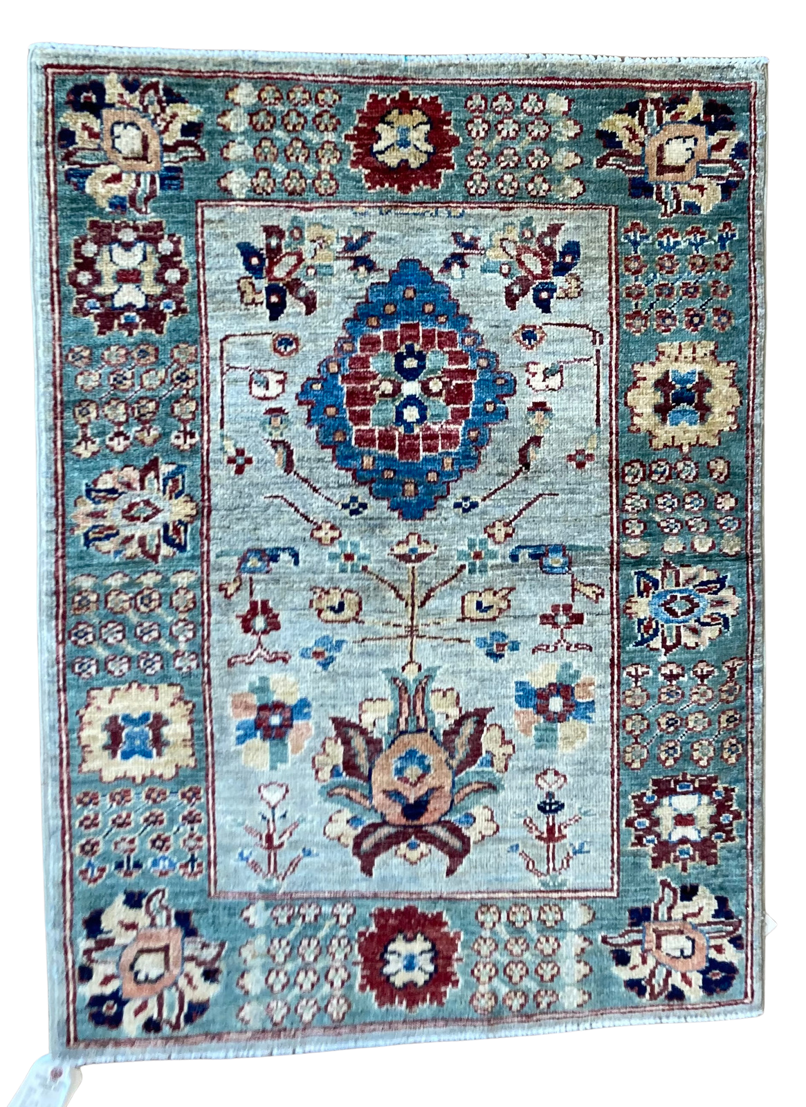 A rug with a floral pattern on it is on a white background.