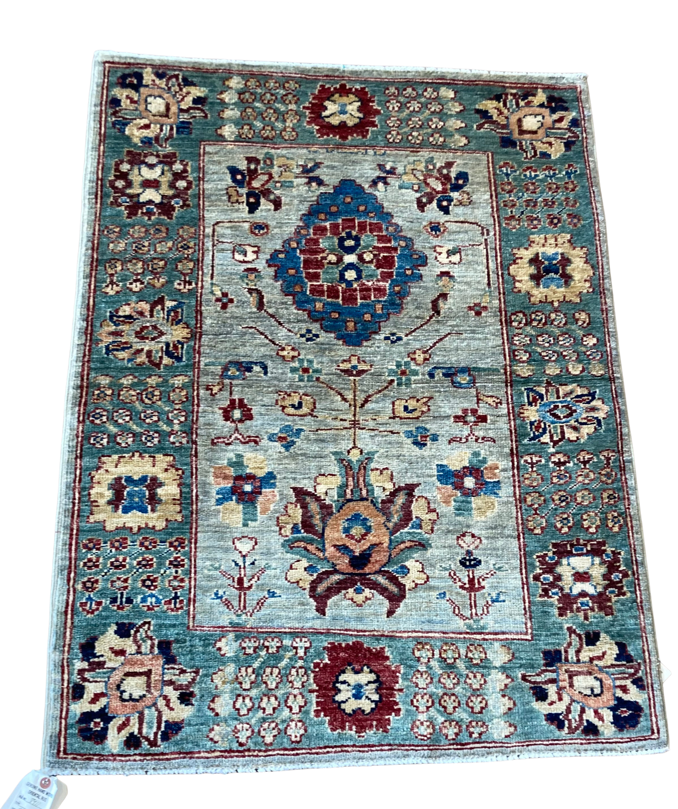 A rug with a floral pattern on it is on a white background.
