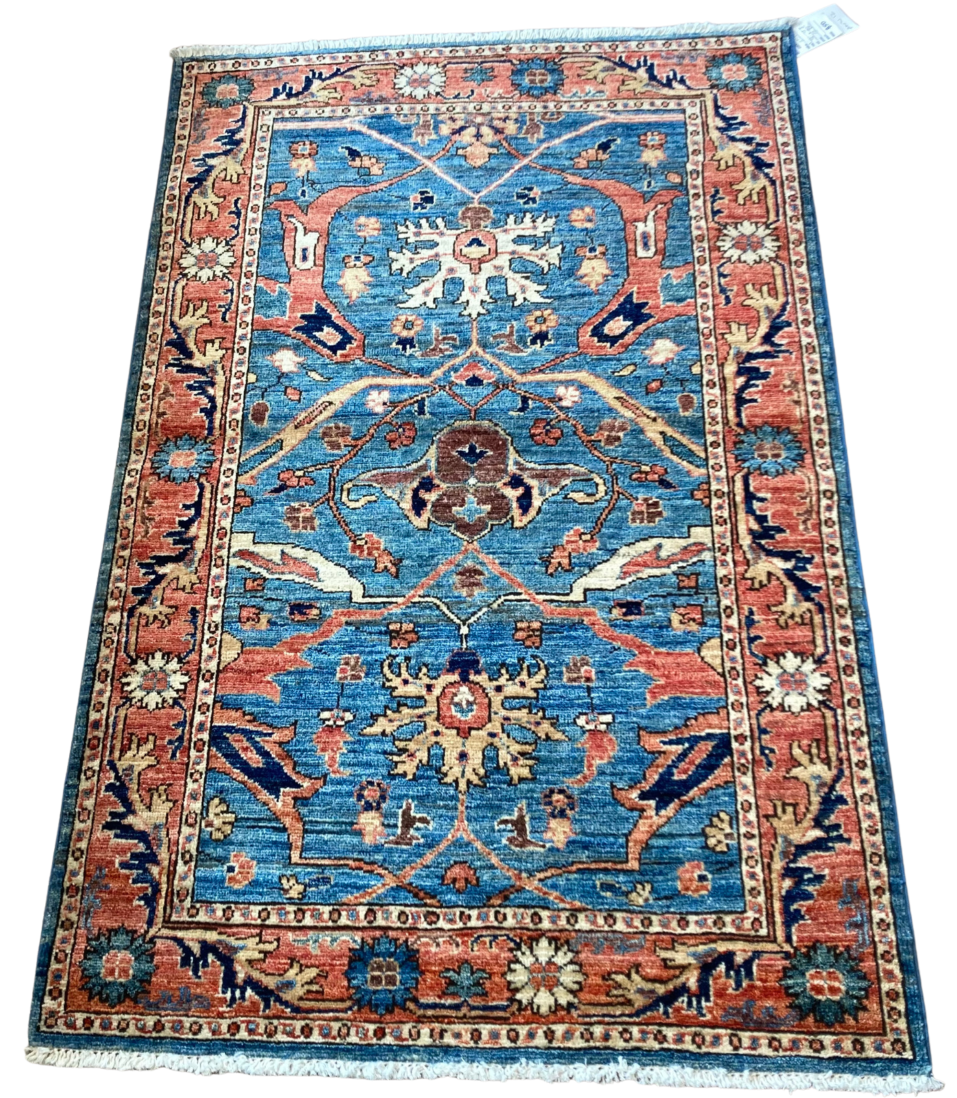 A blue and red rug with a floral pattern on a white background.