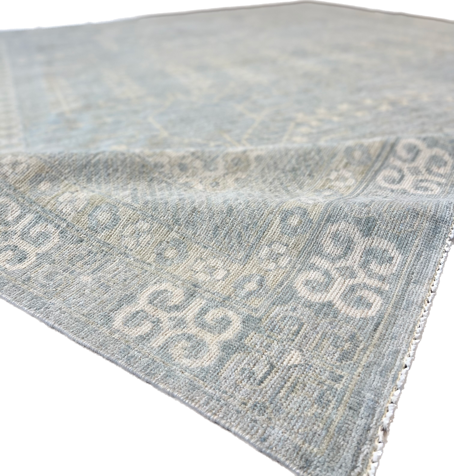 A rug with a pattern on it is sitting on a white surface.