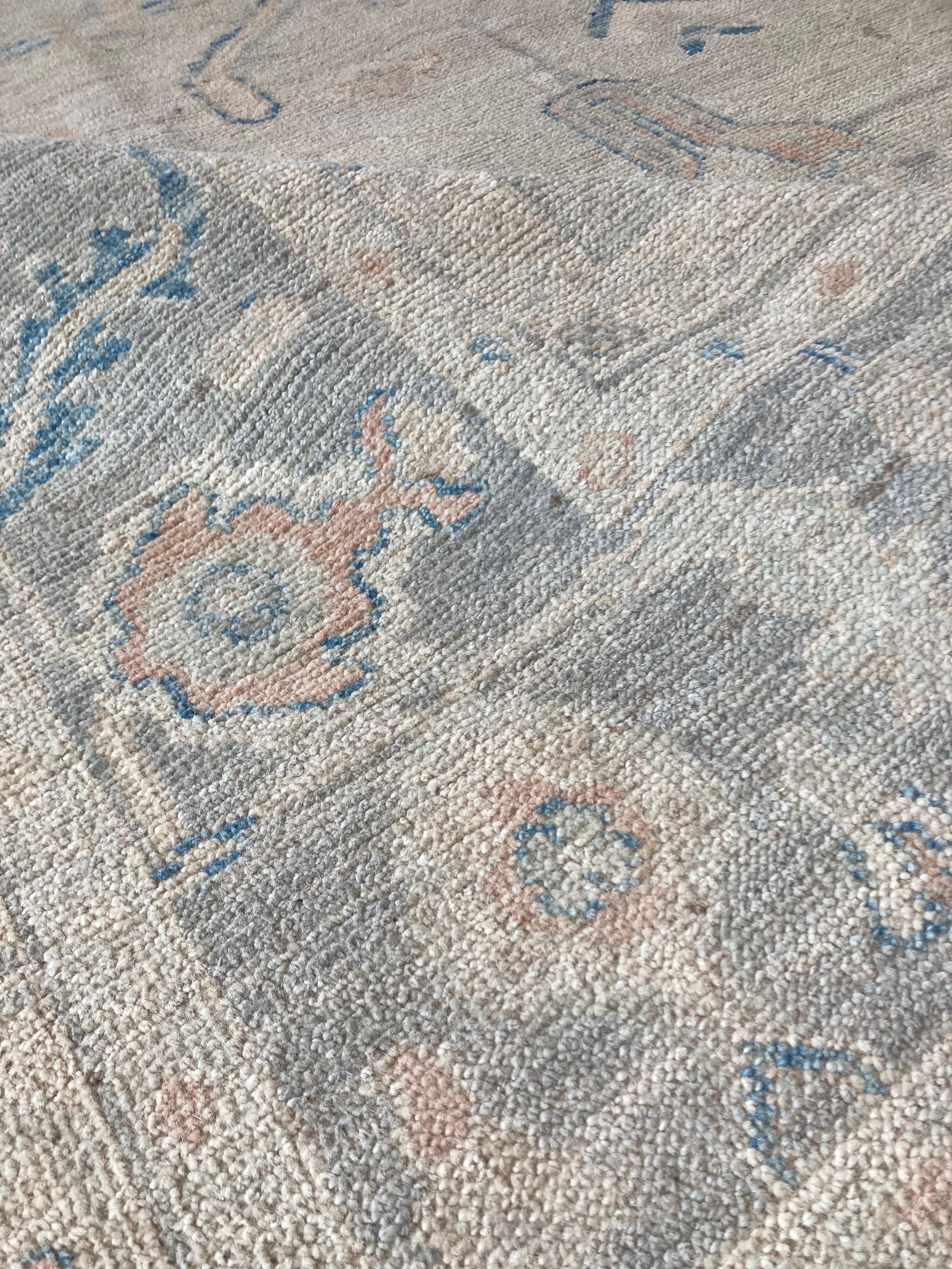 A rug with a blue border is sitting on a white surface.