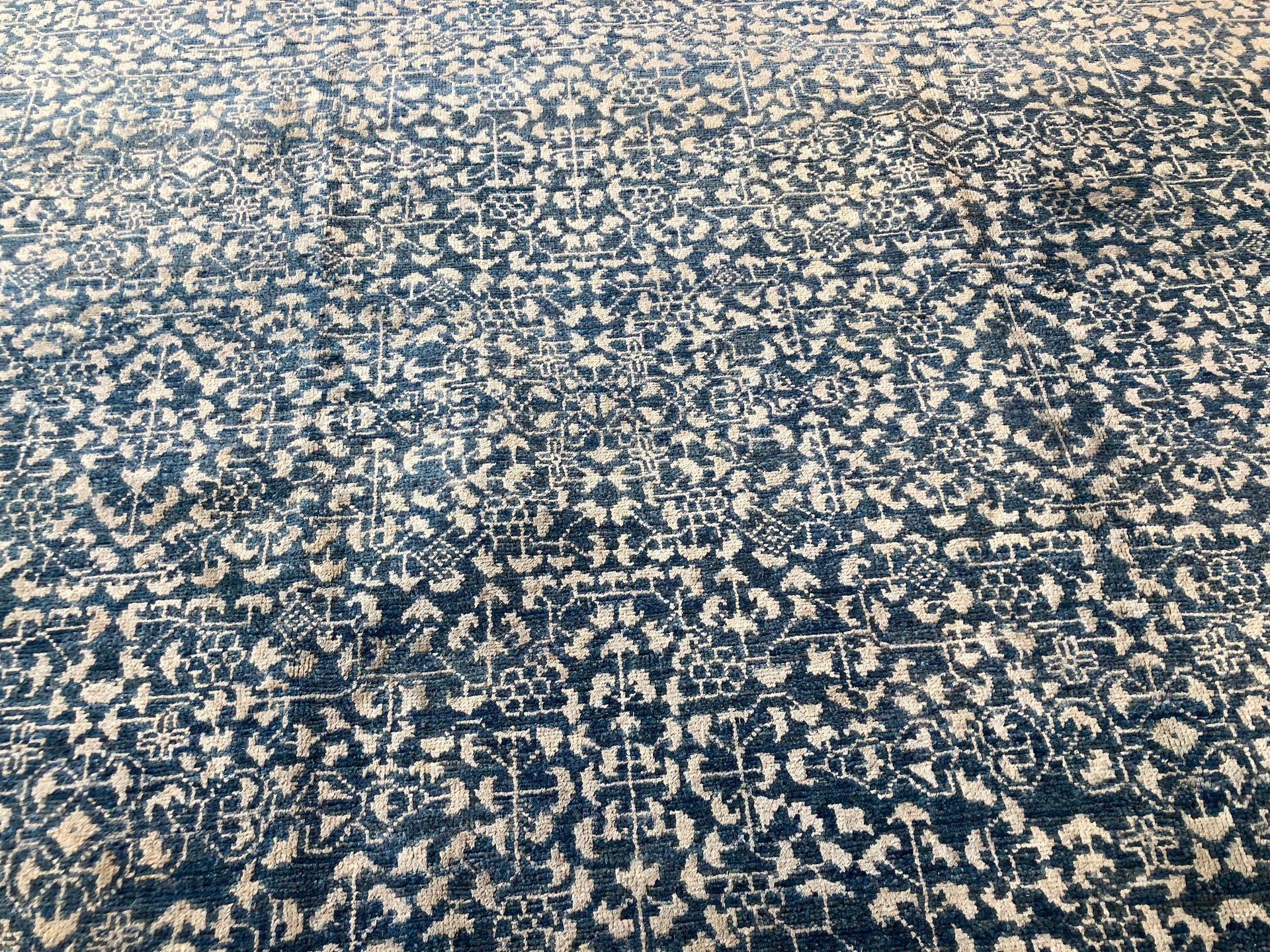 A close up of a blue and white rug with a pattern on it.