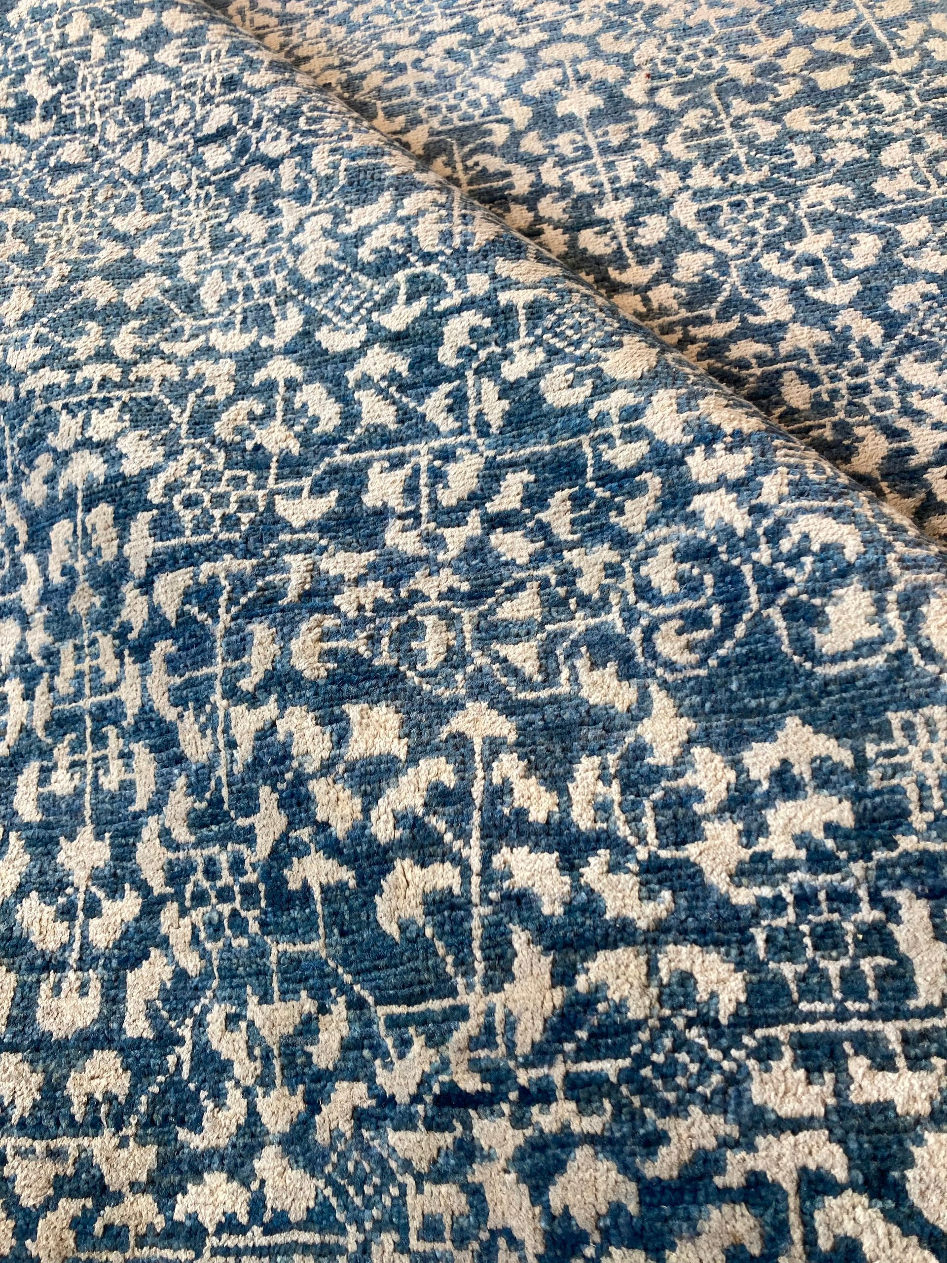 A close up of a blue and white rug with a pattern on it.