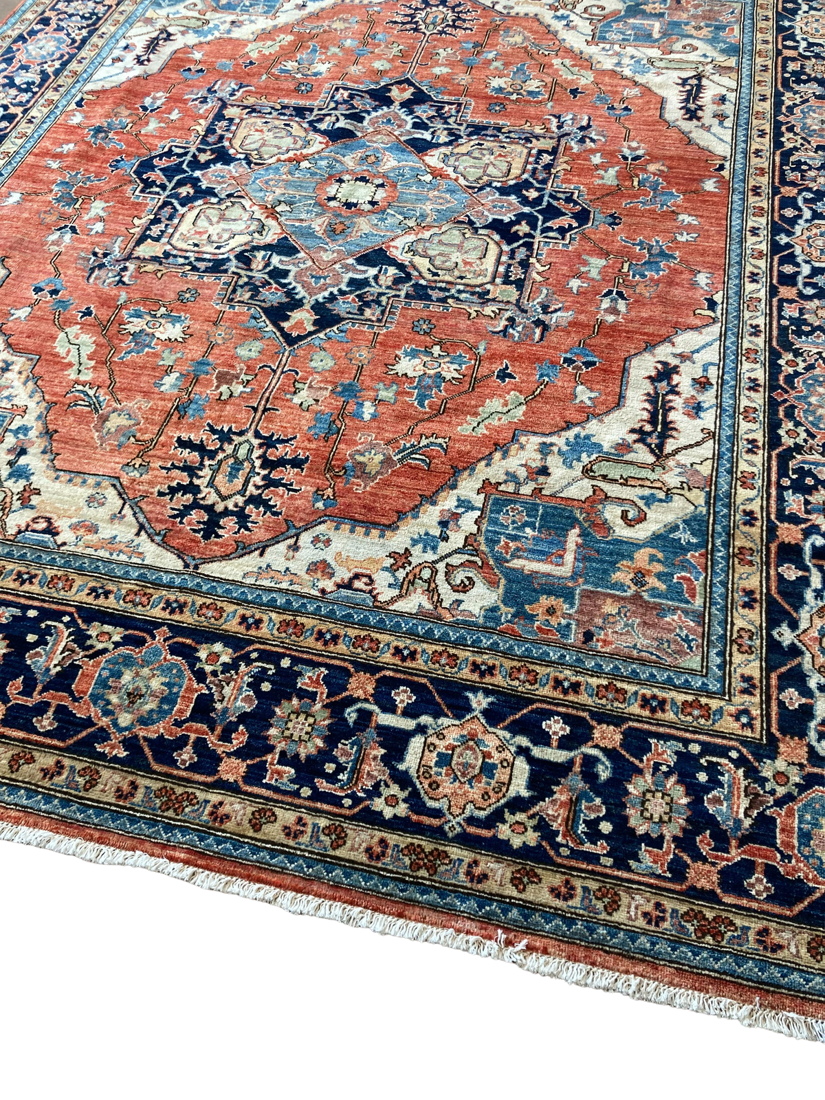 A red and blue rug with a floral pattern on a white background.