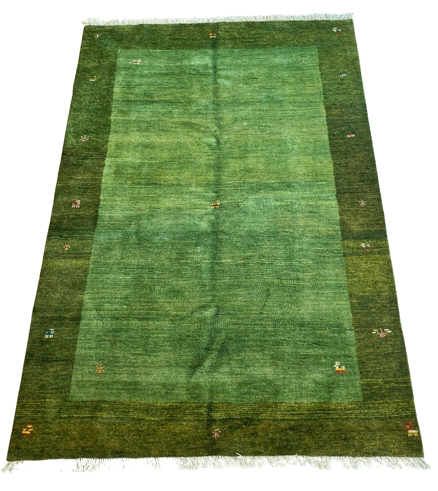 A green rug is sitting on a white surface.