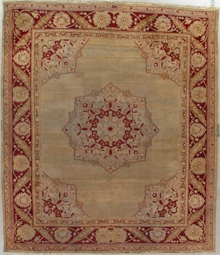A rug with a circular design and a red border