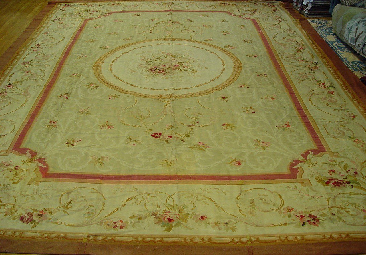 A large rug is sitting on a wooden floor in a living room.