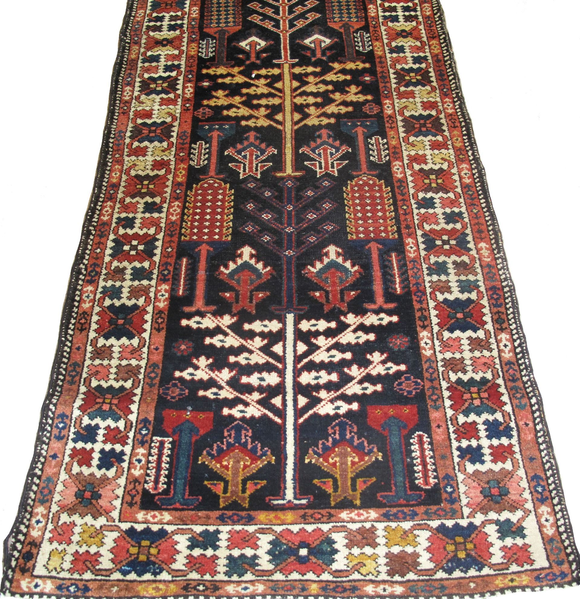 A colorful rug with a tree design and a few buildings on it