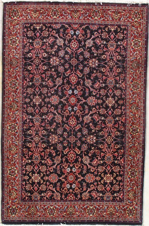 A rug with a floral pattern on it is hanging on a wall.