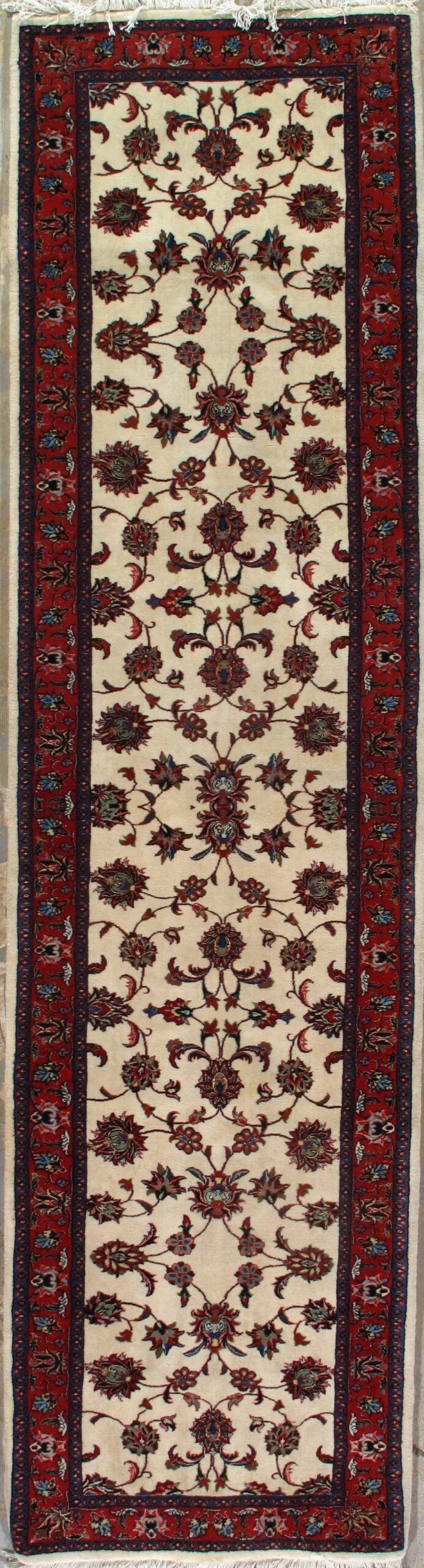 A rug with a floral pattern on it is hanging on a wall.