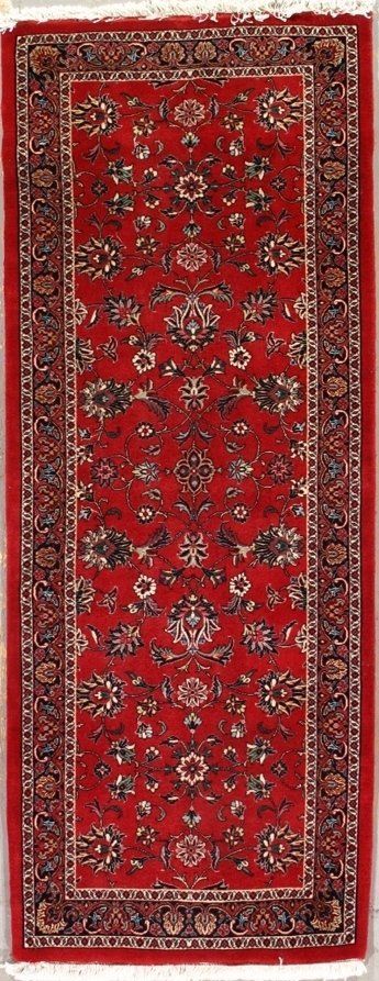 A red rug with a floral pattern on it is sitting on a table.