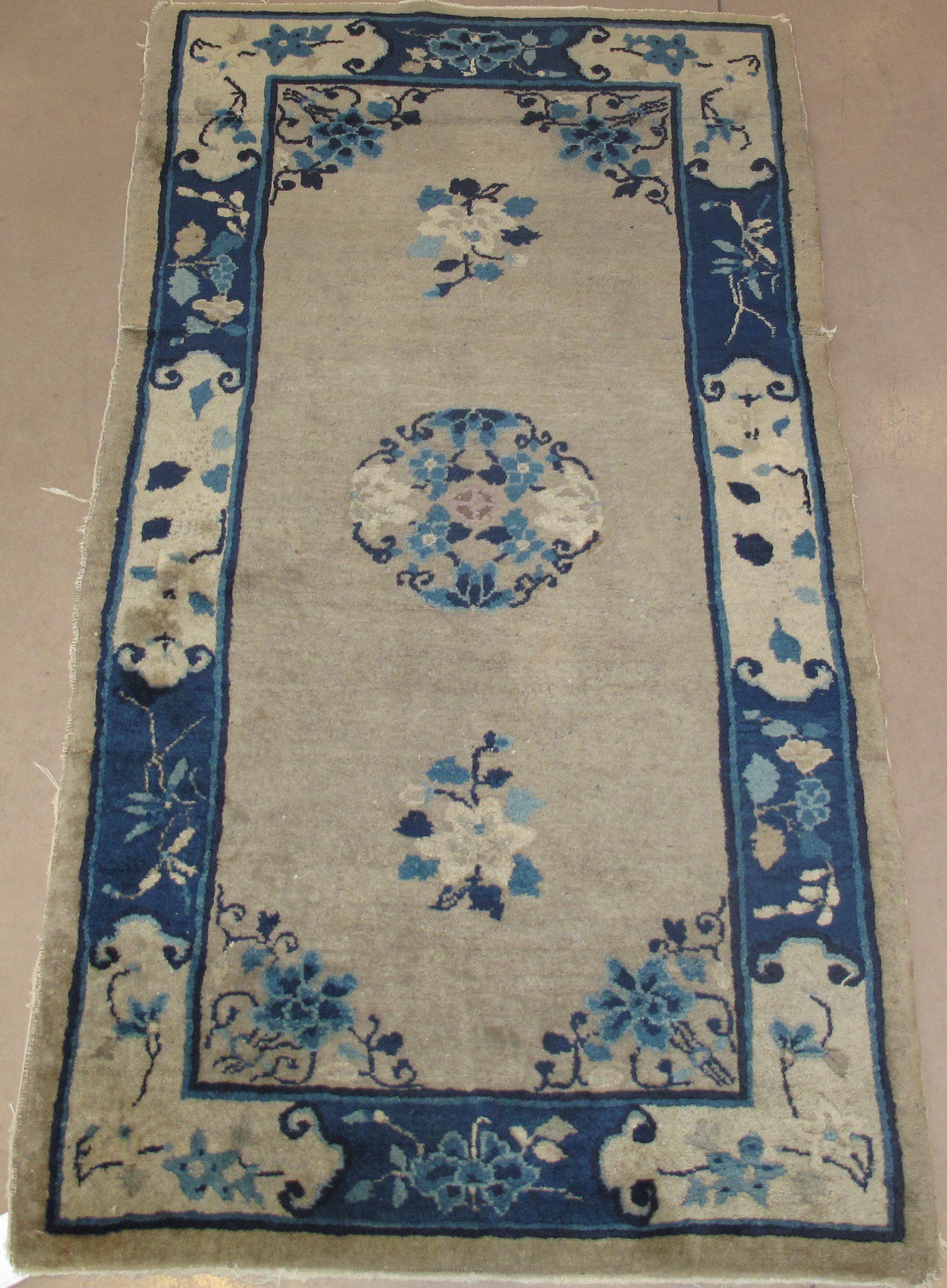 A rug with blue and white flowers on it
