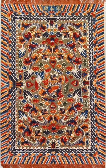 A rug with a floral pattern on it is hanging on a wall.