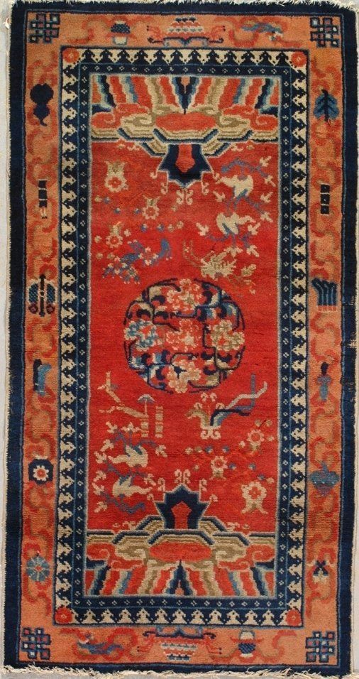 A red rug with a blue border and flowers on it