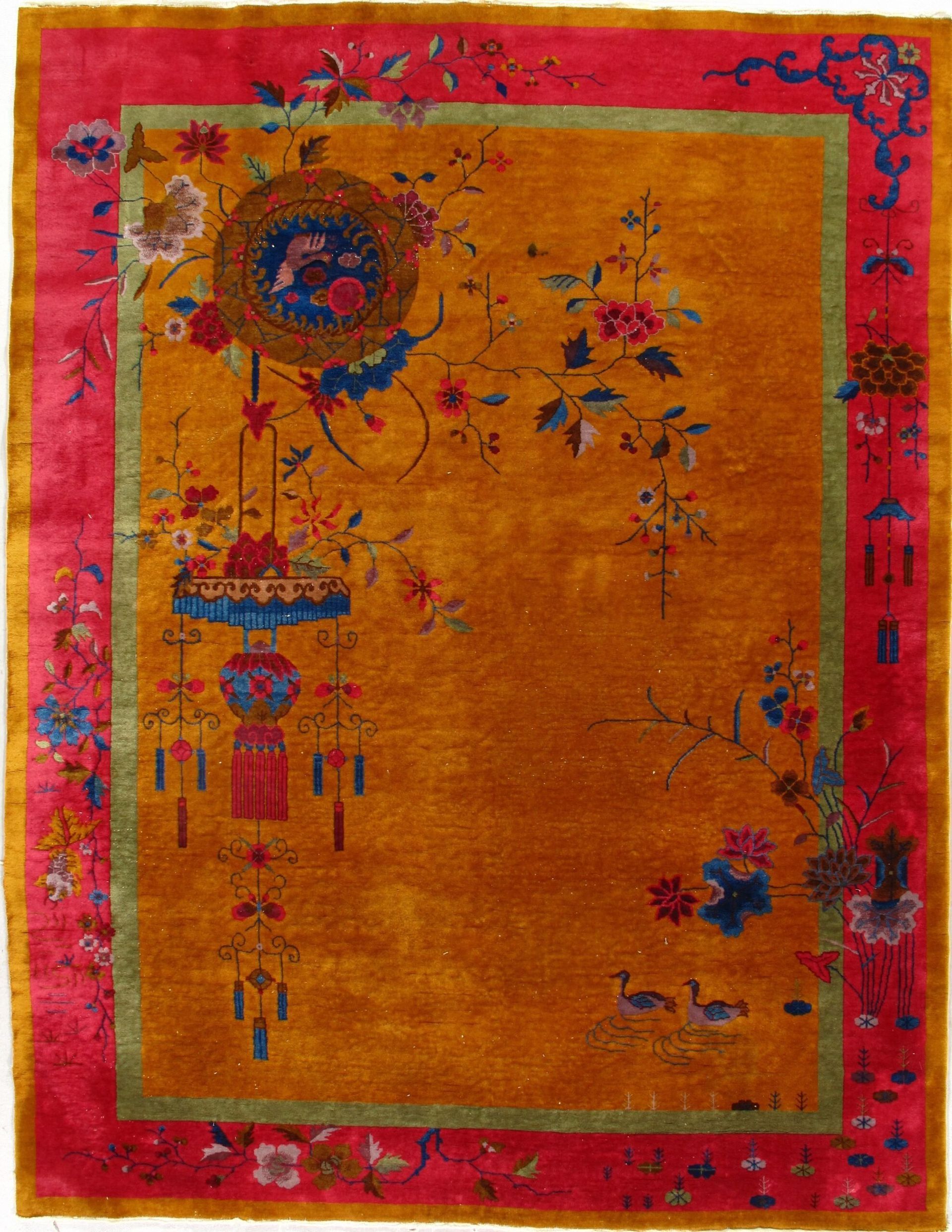 A yellow rug with a red border and flowers on it.