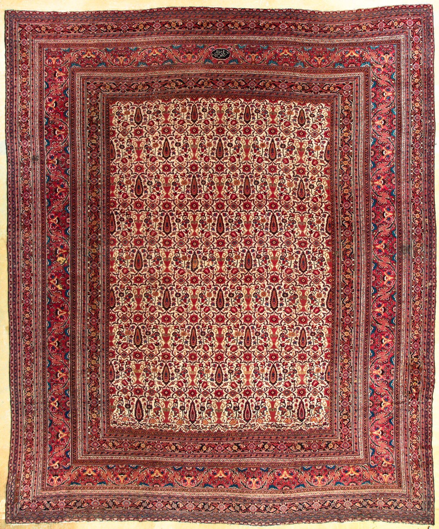 A square rug with a floral pattern on it is sitting on a table.