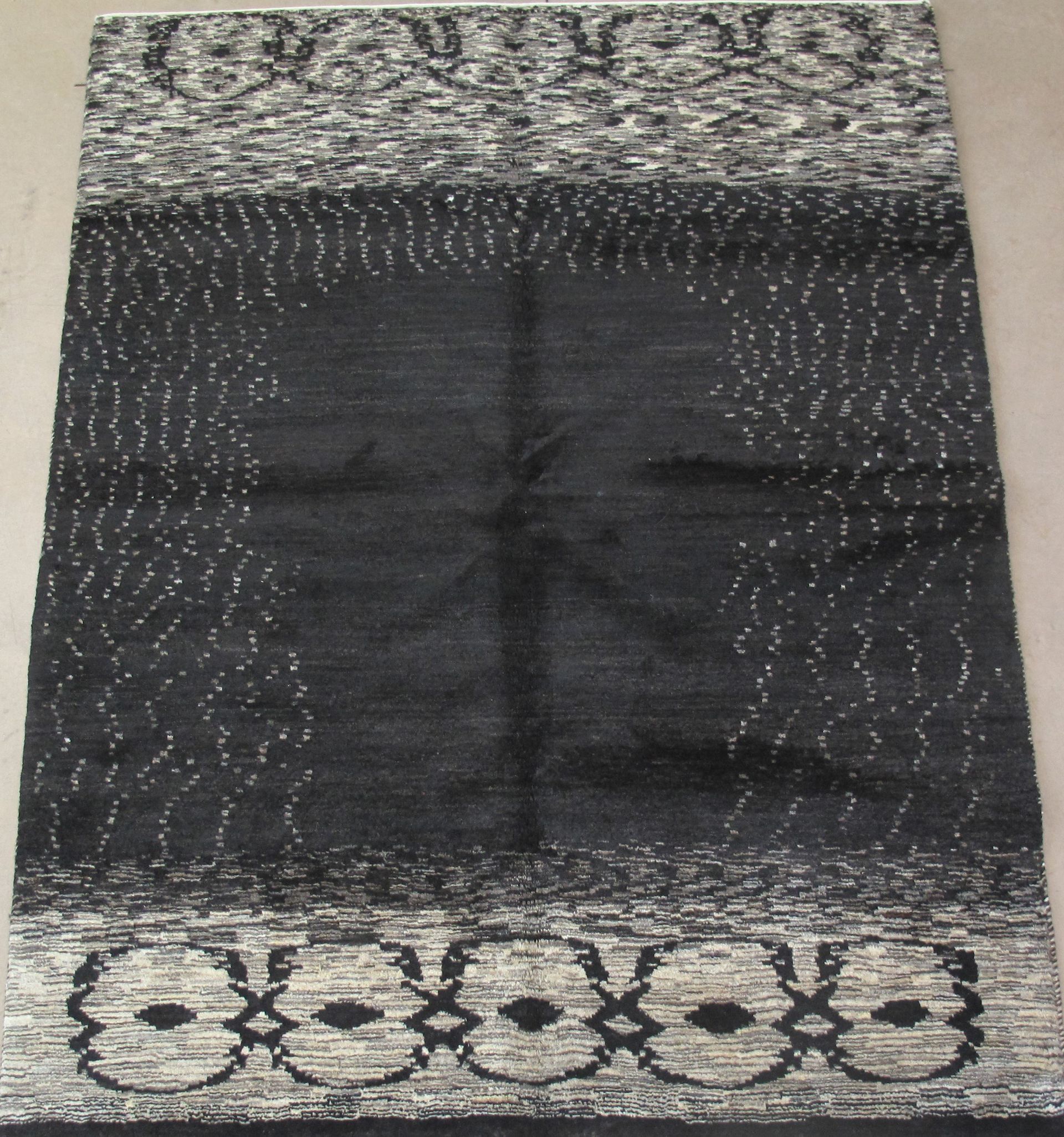 A black and white rug with a cross on it