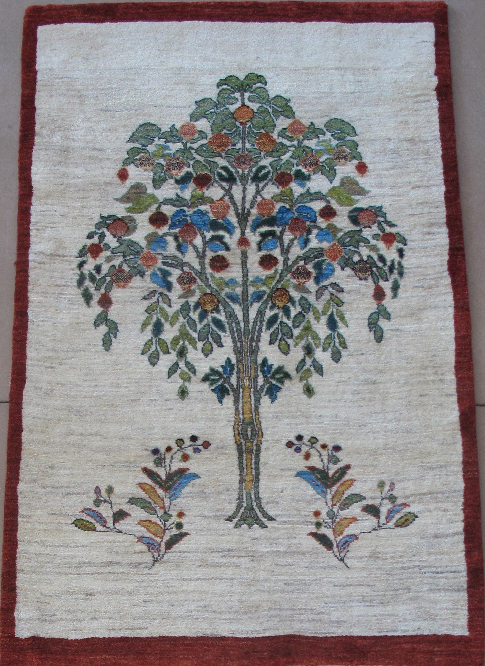 A rug with a tree and flowers on it