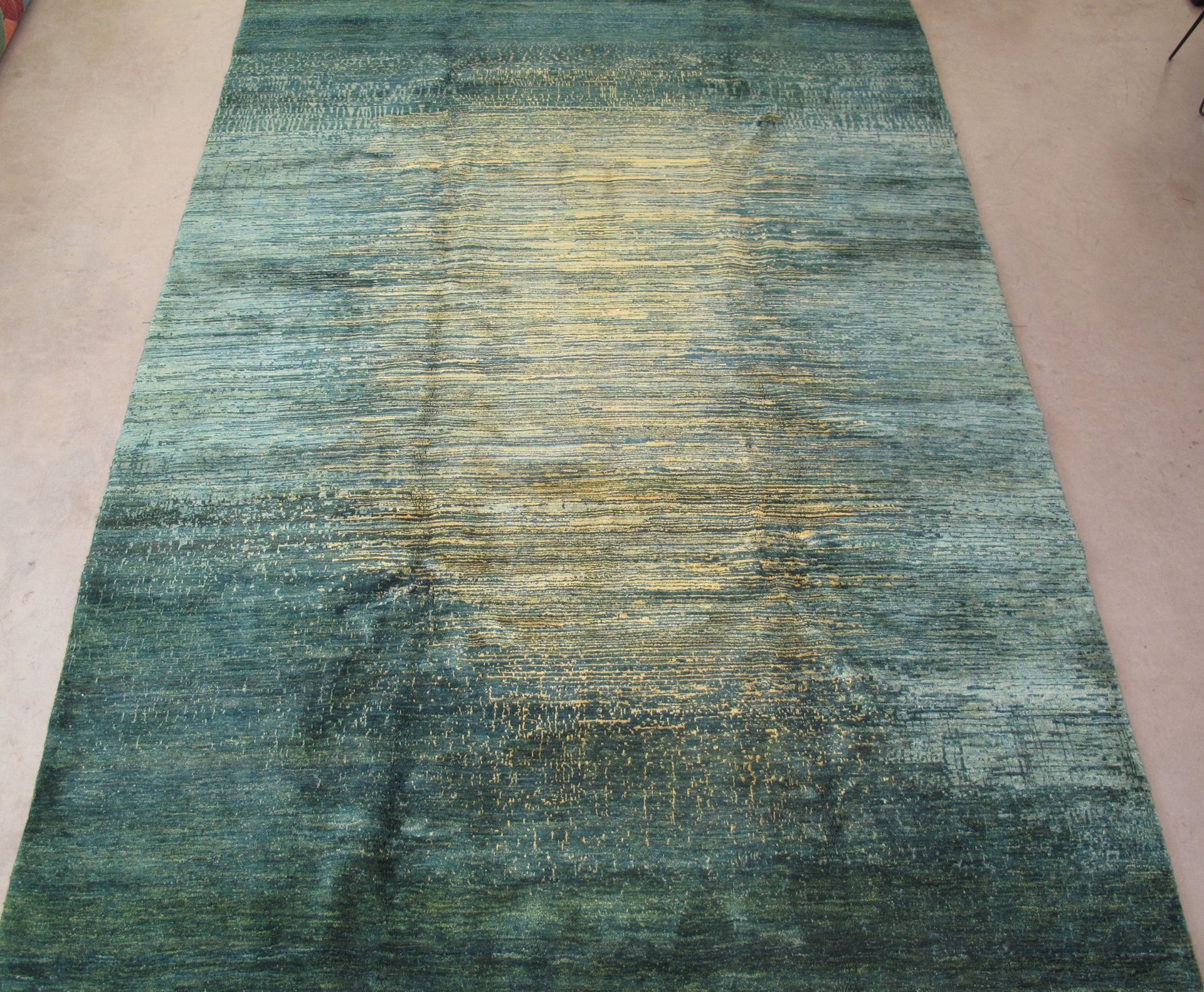 A green and gold rug is laying on the floor