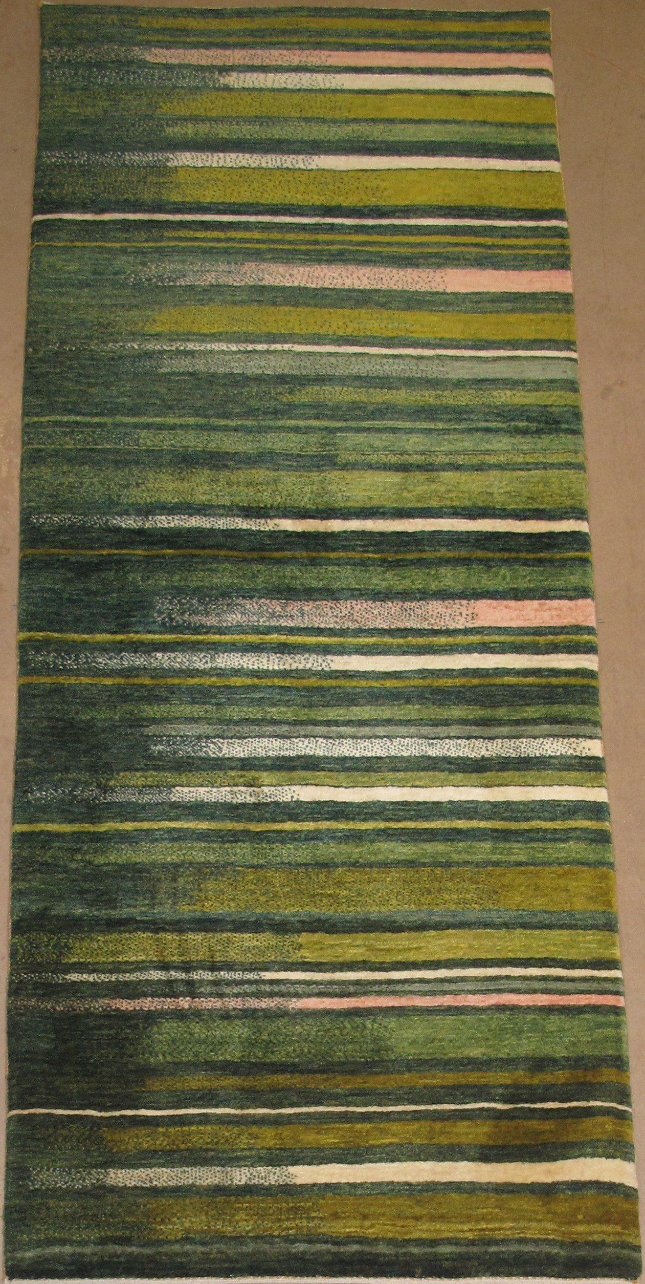 A green and white striped rug is sitting on a wooden floor.