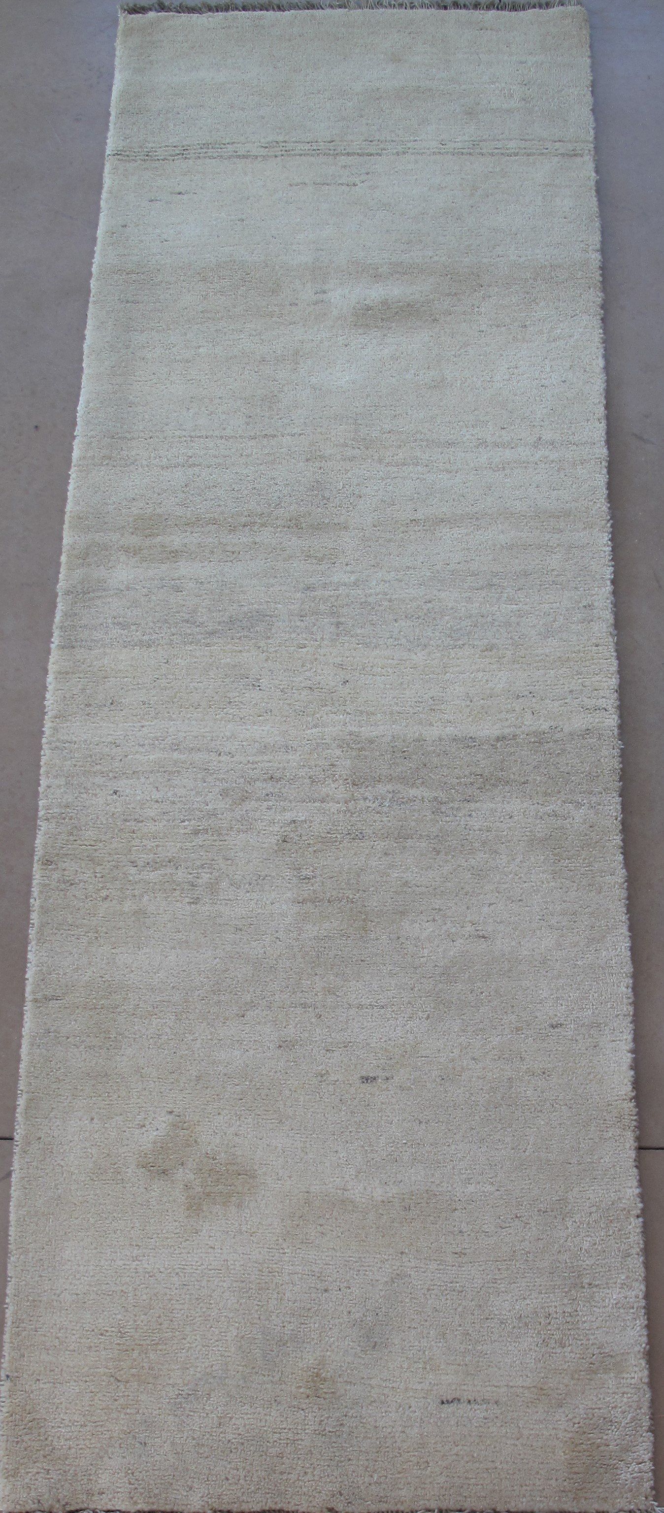 A white rug is sitting on a wooden floor.