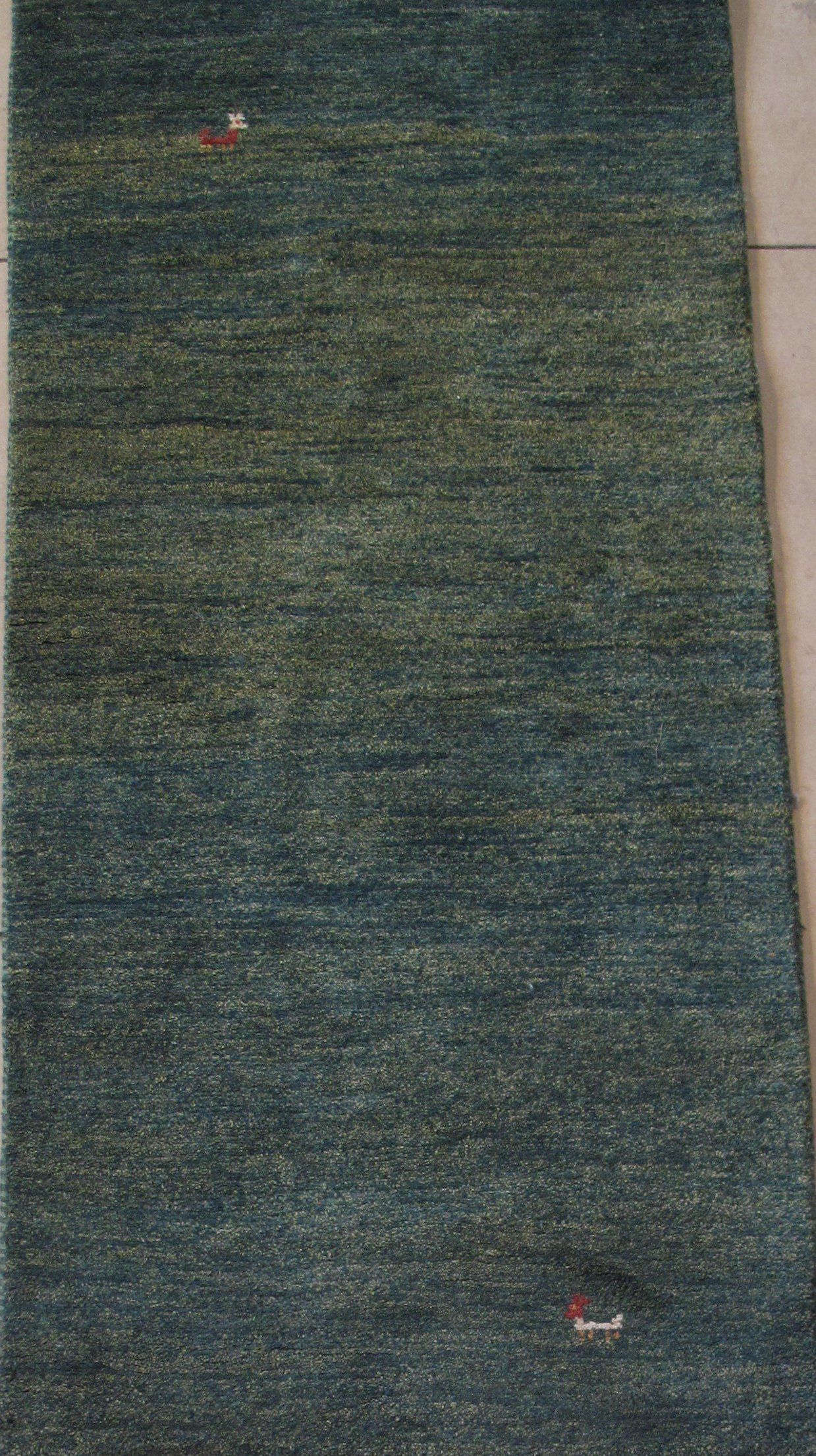 A green rug is sitting on top of a white surface.