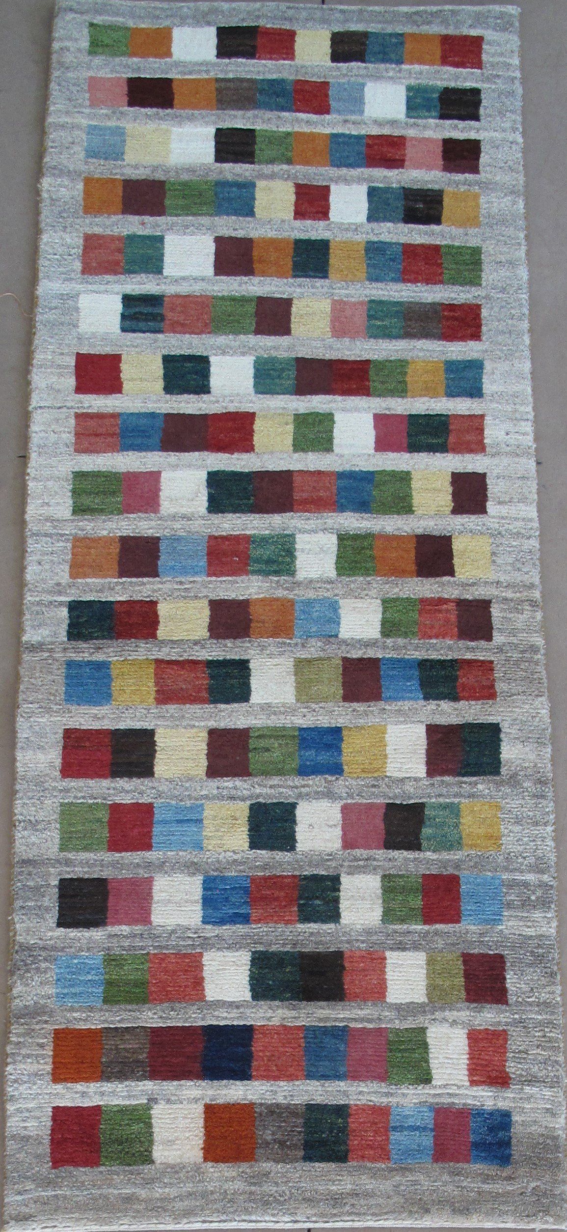 A colorful rug with squares on it is sitting on a table.