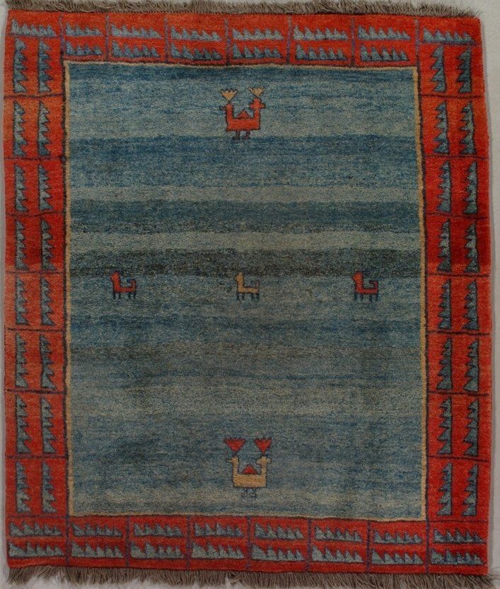 A blue and red rug with a deer on it