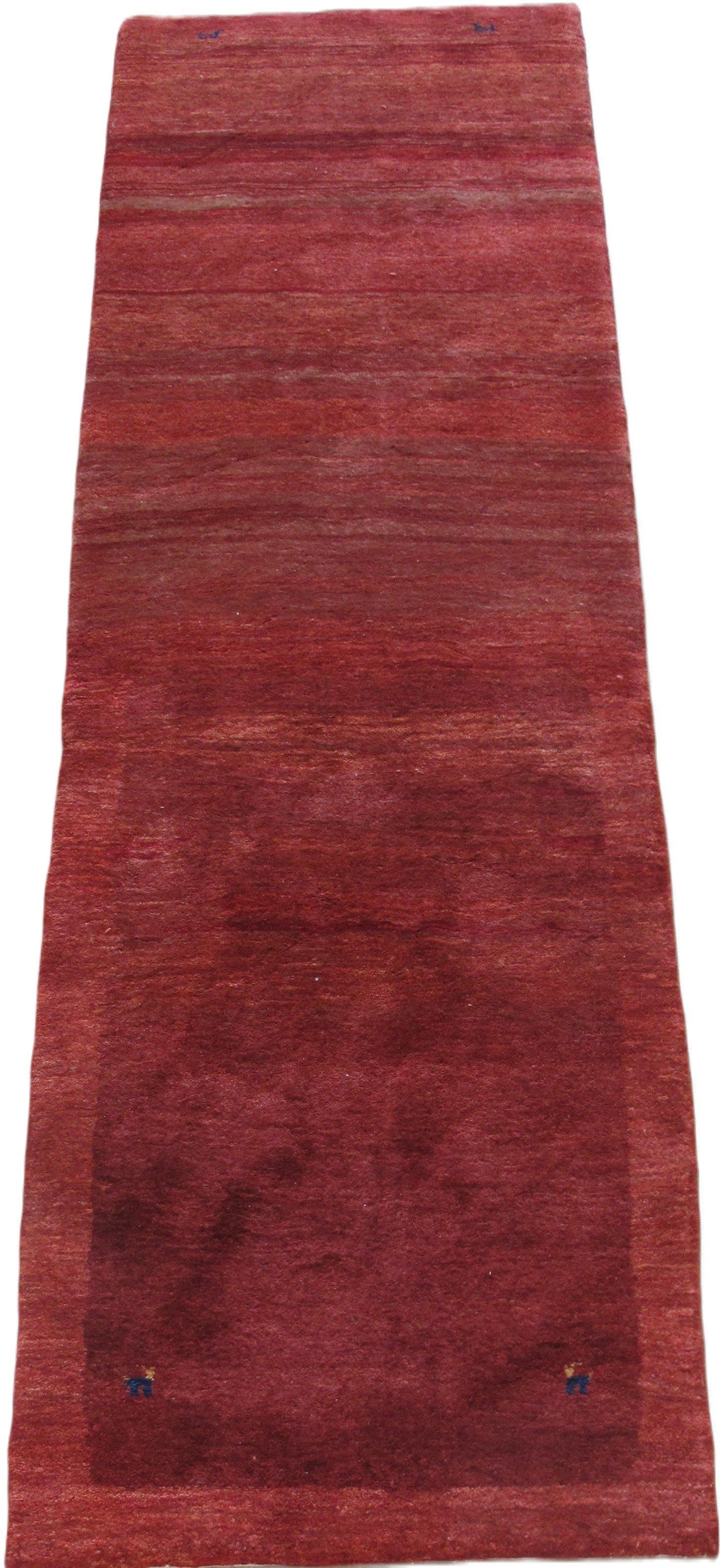 A red rug is sitting on a white surface.