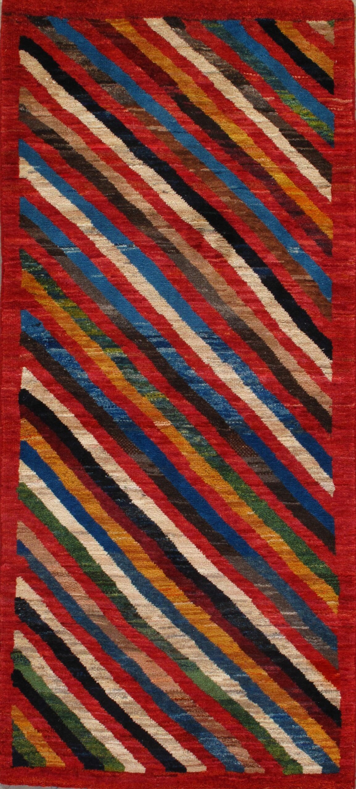 A colorful striped rug with a red border is sitting on a table.