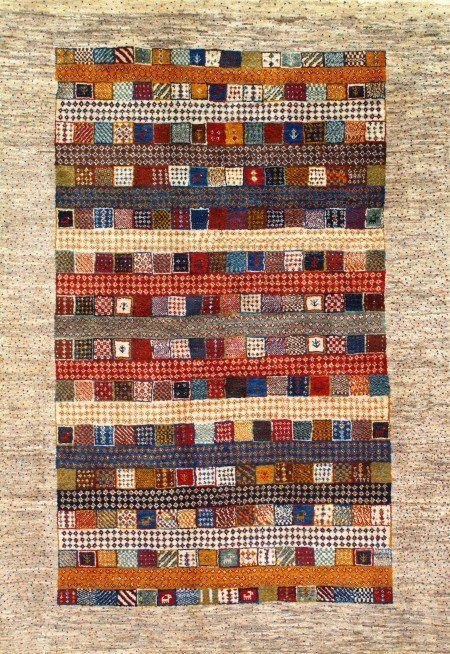 A rug with a pattern of squares on it is hanging on a wall.