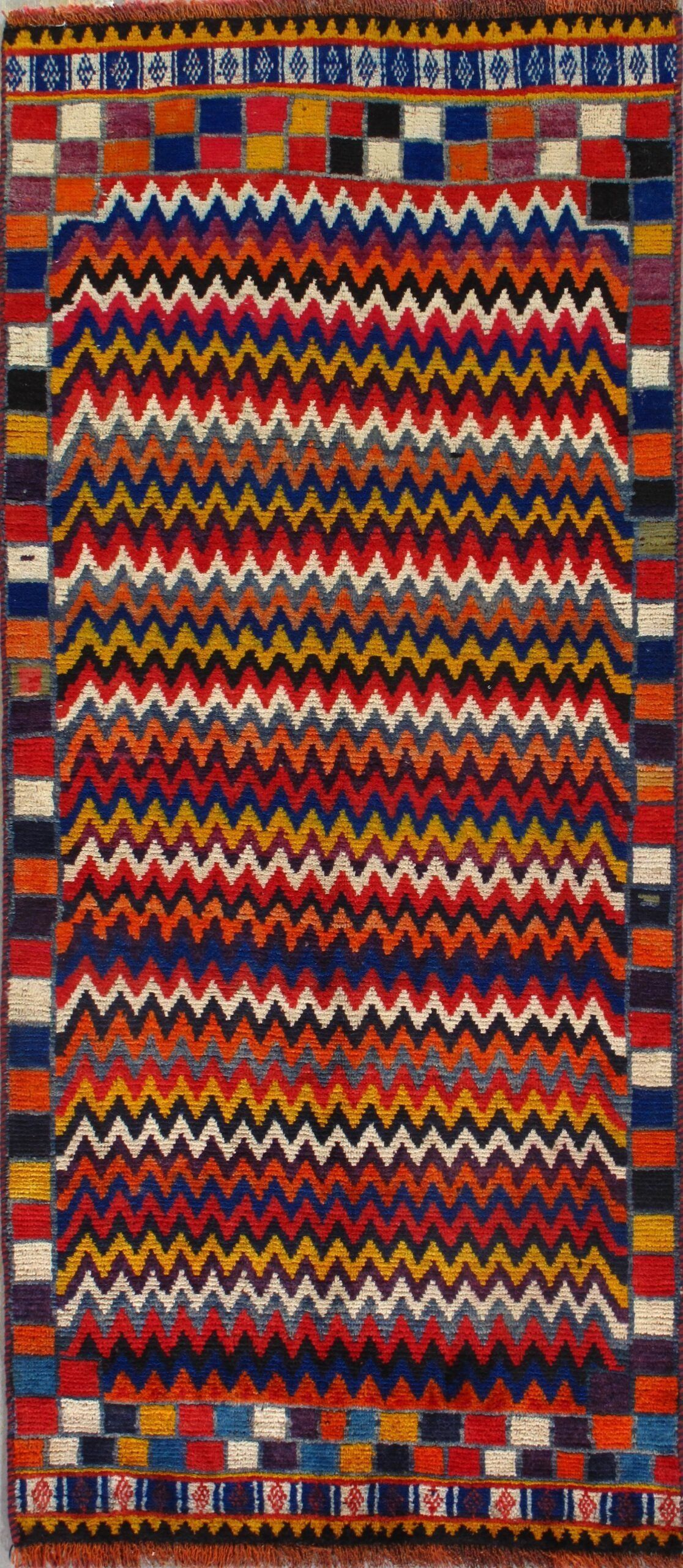 A colorful rug with a geometric pattern on it is sitting on a table.