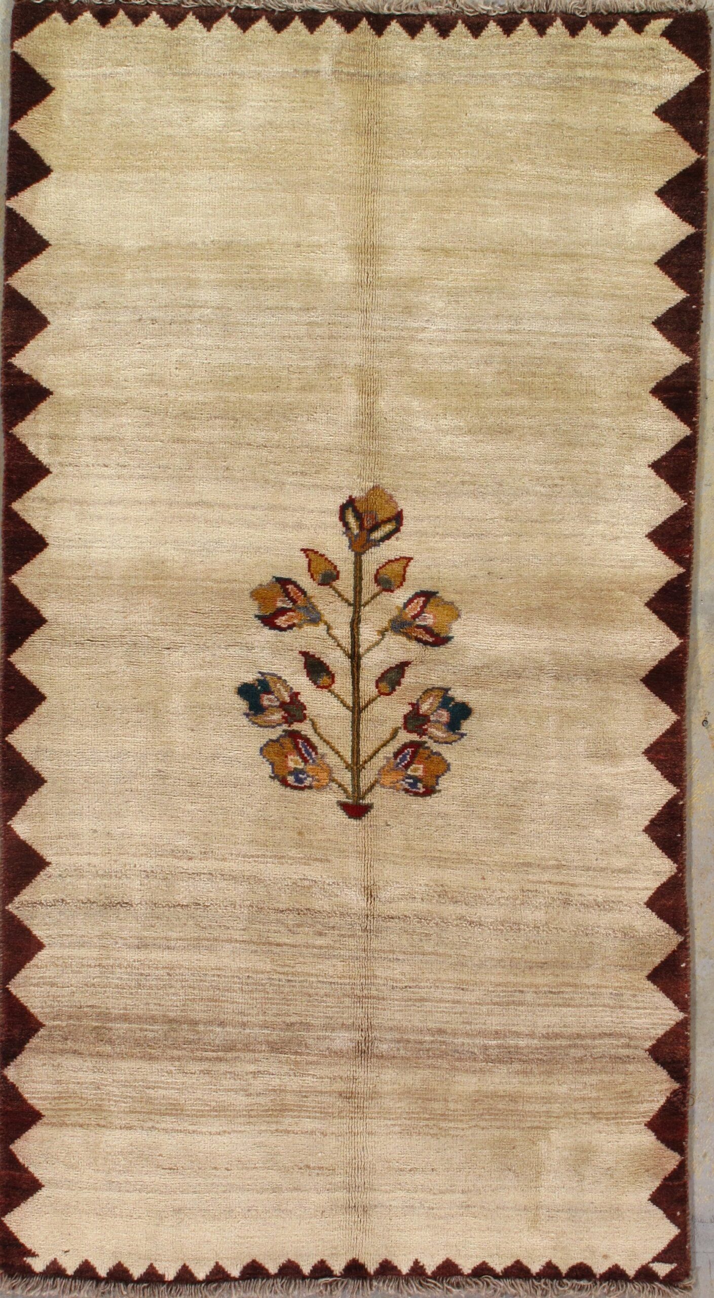 A rug with a tree on it is hanging on a wall.