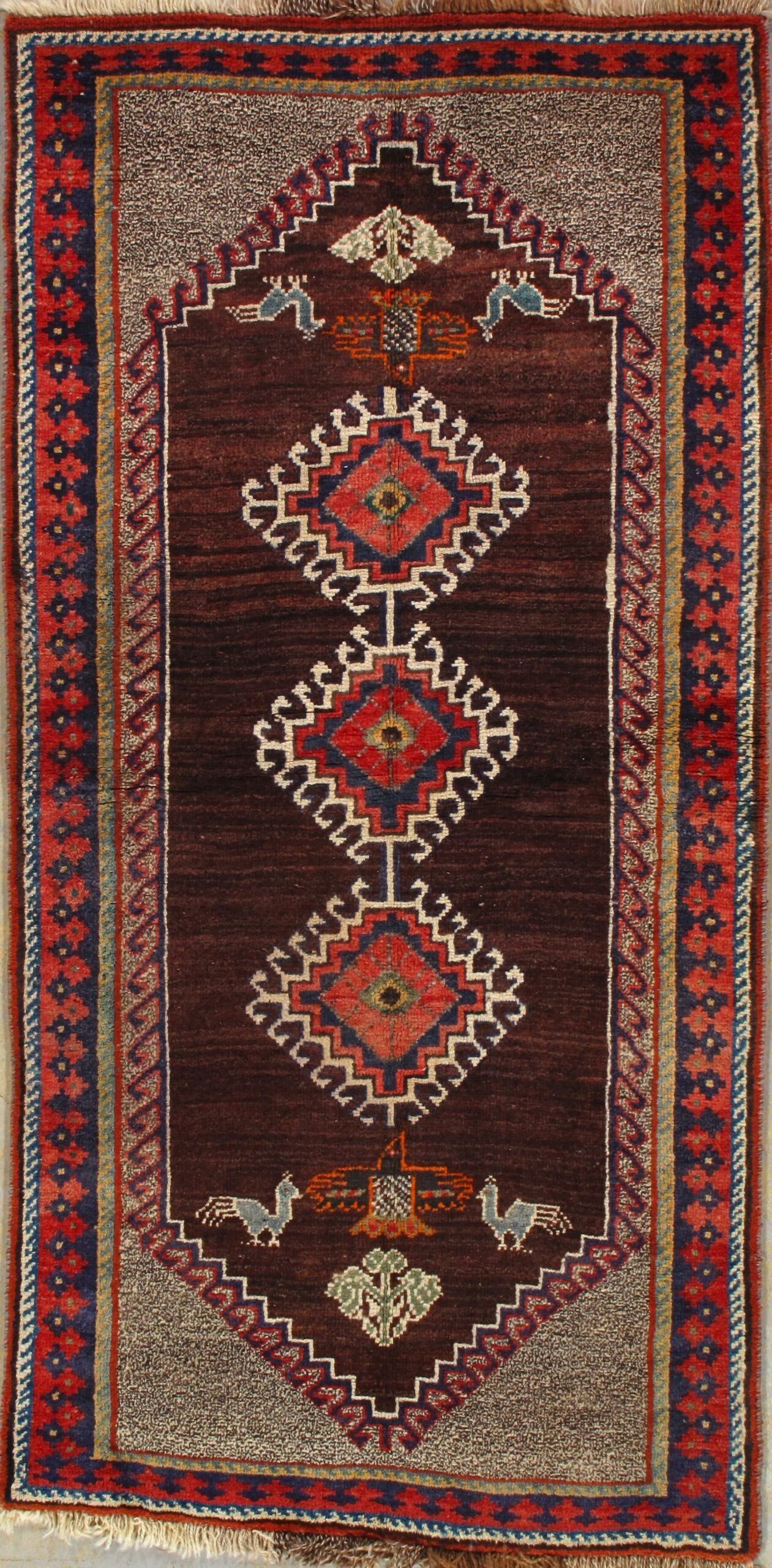 A rug with a geometric pattern on it is hanging on a wall.