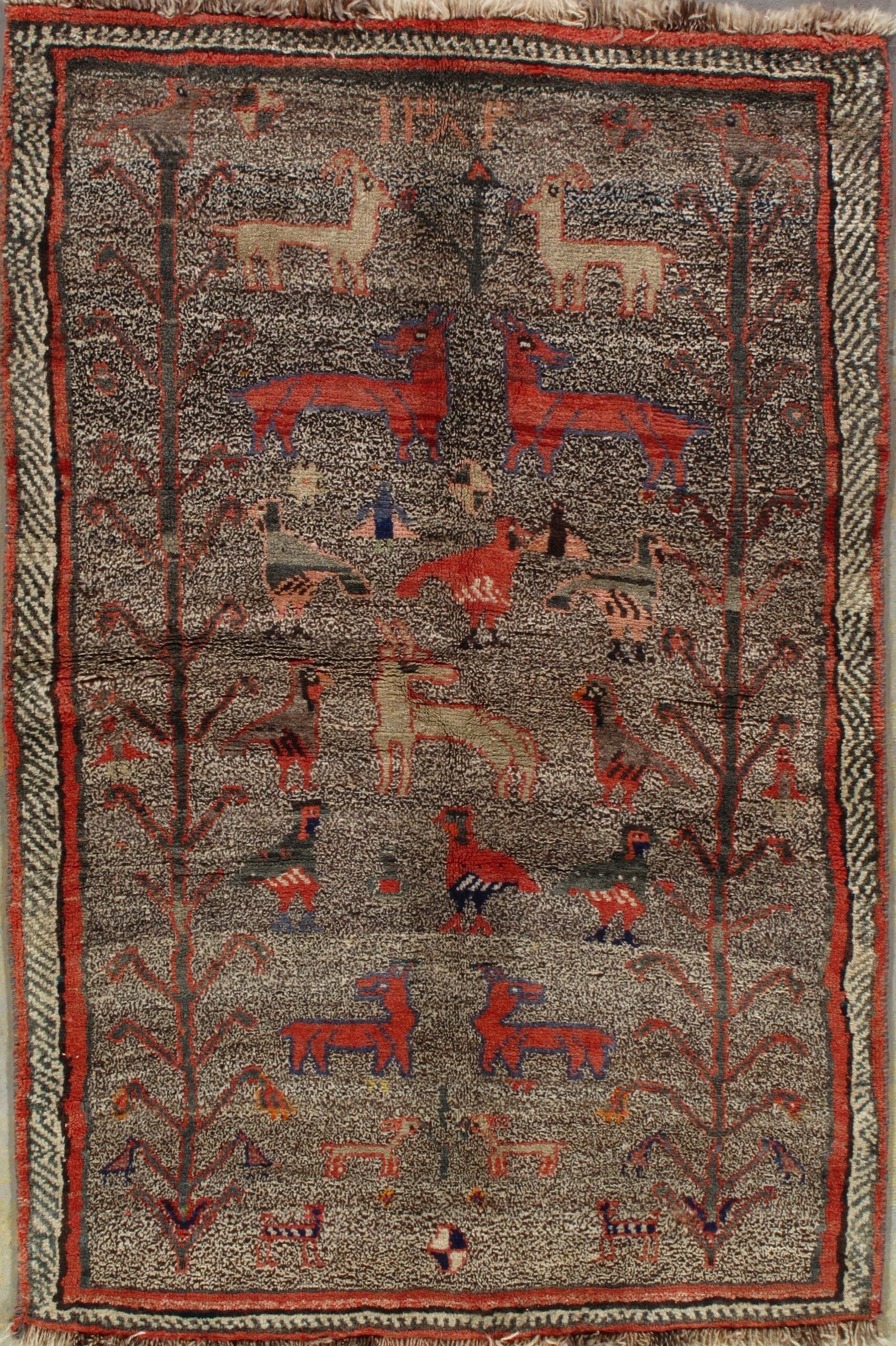 A rug with a pattern of deer and trees on it.