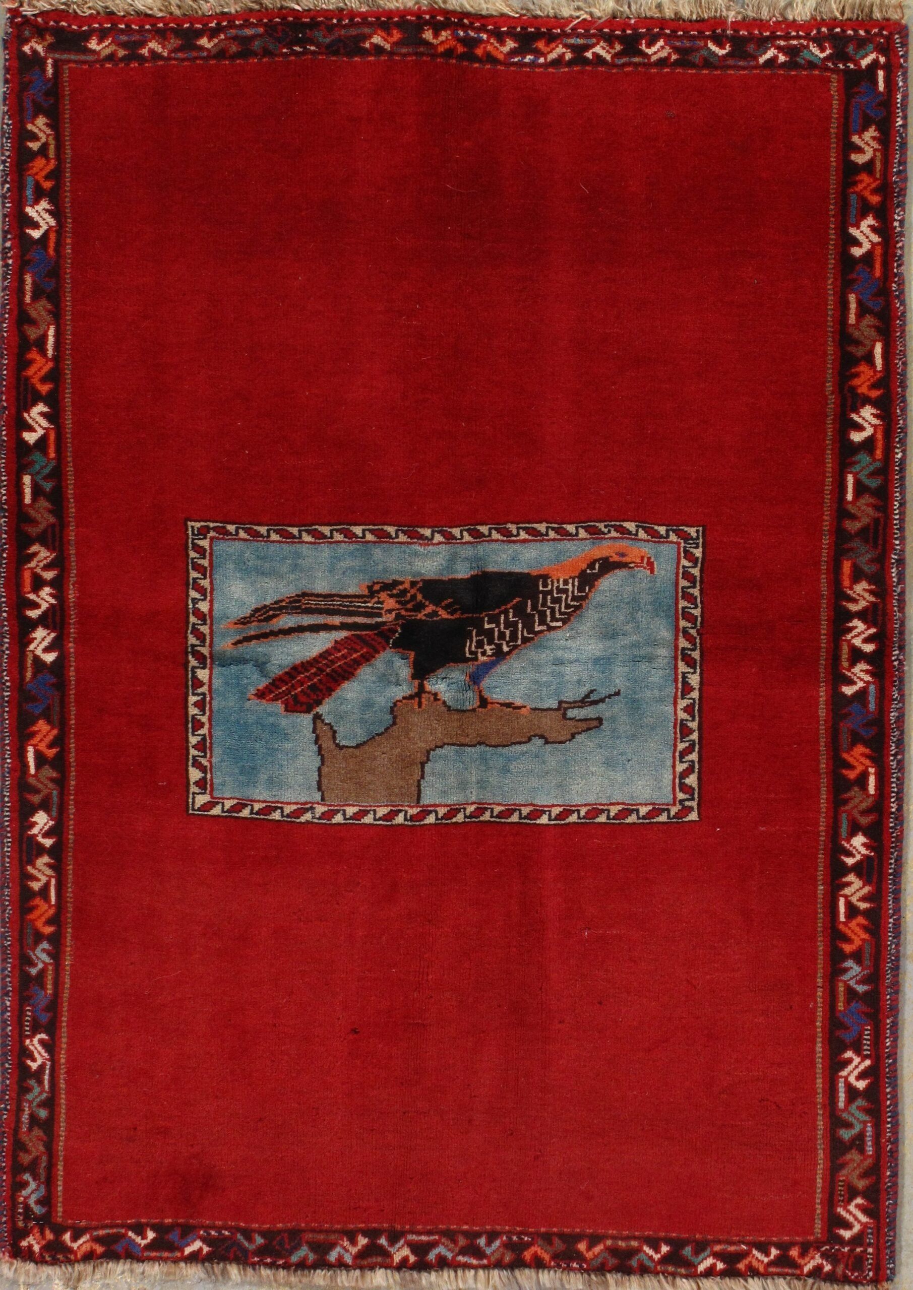 A red rug with a picture of a bird on it