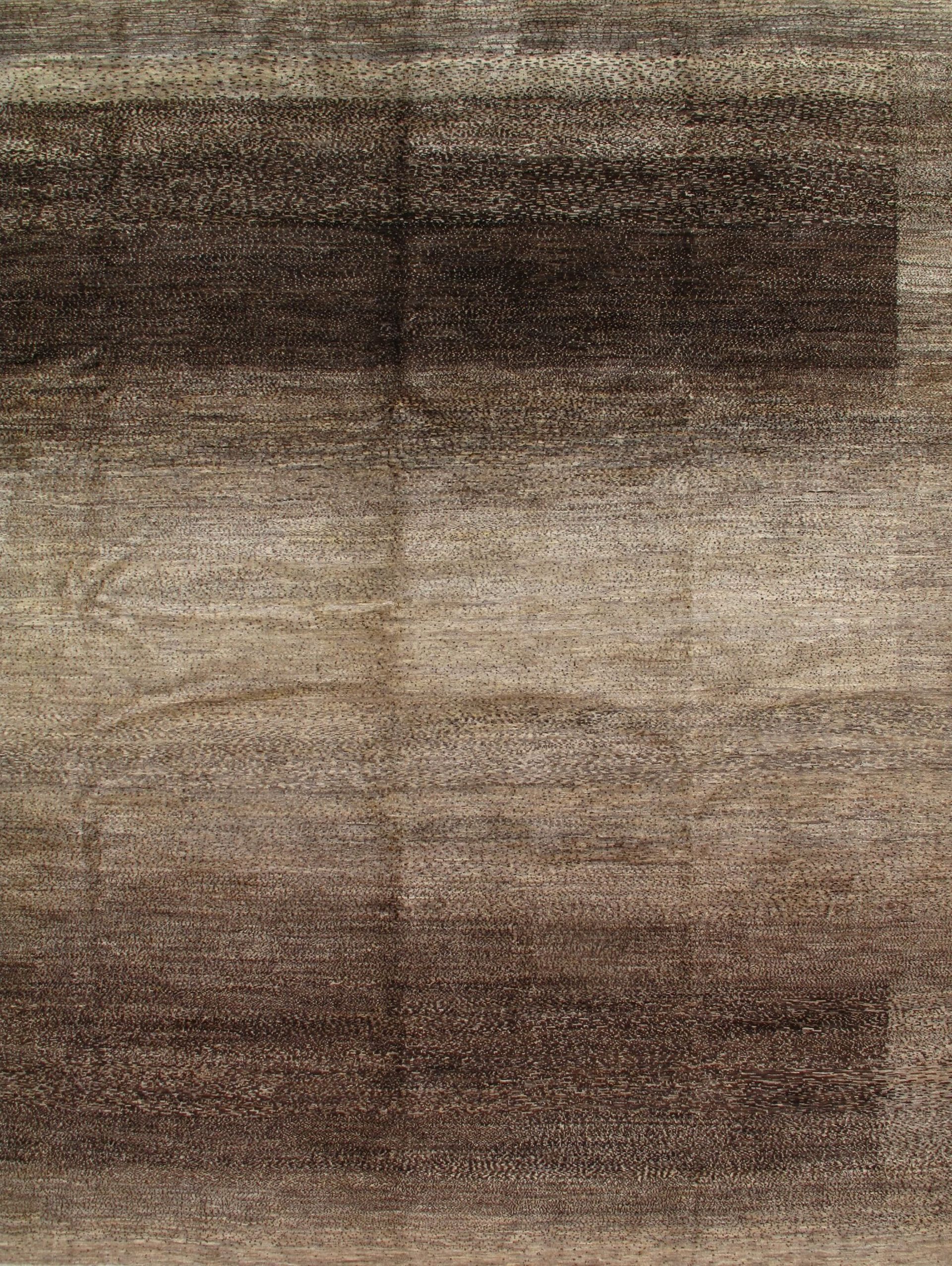A close up of a brown rug with a brick wall in the background.