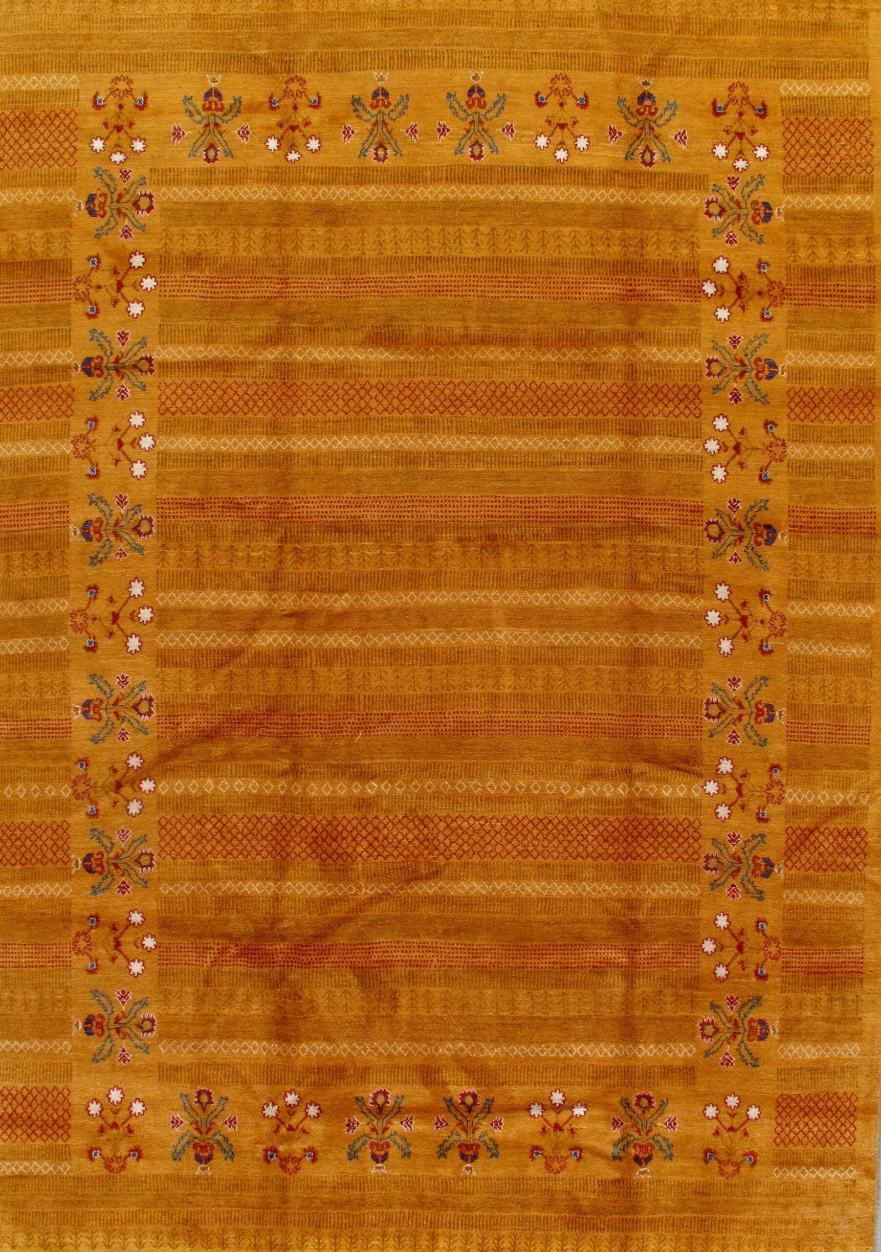 A close up of a yellow rug with a floral pattern on it.