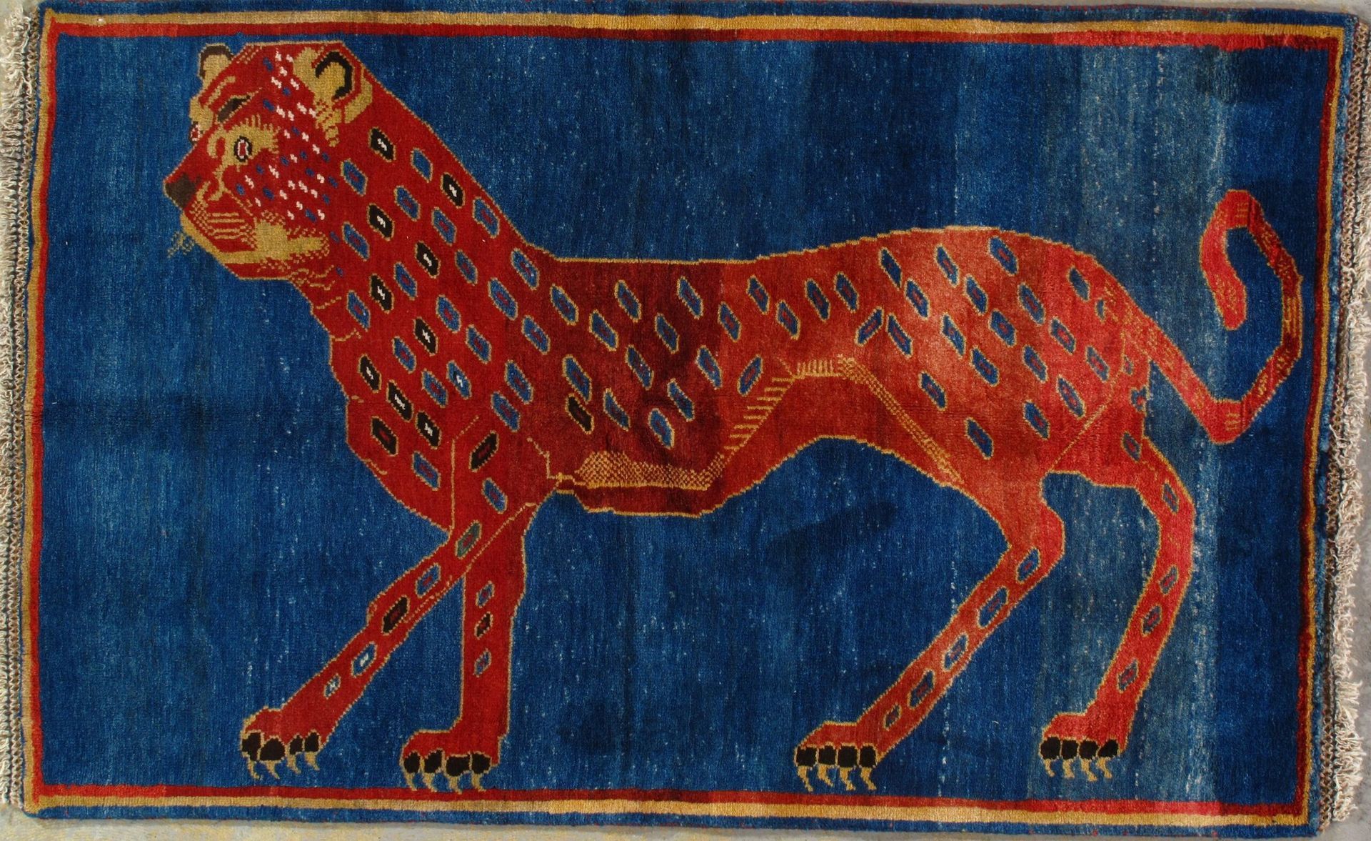 A rug with a red leopard on a blue background