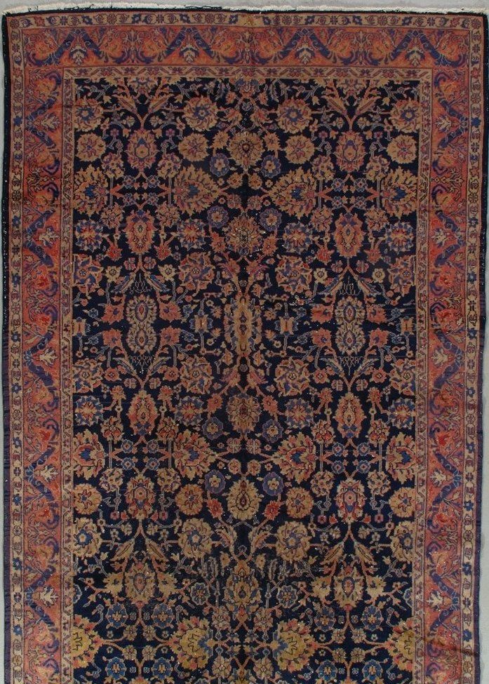 A rug with a floral pattern on it is hanging on a wall.