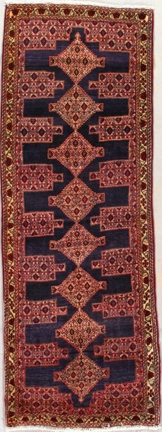 A rug with a geometric pattern on it is hanging on a wall.