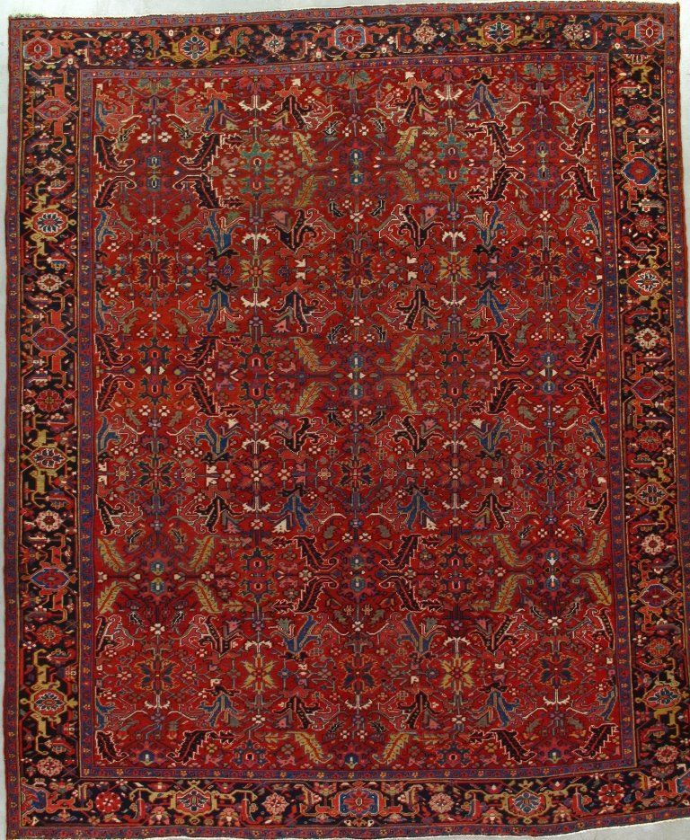 A red rug with a floral pattern is hanging on a wall.