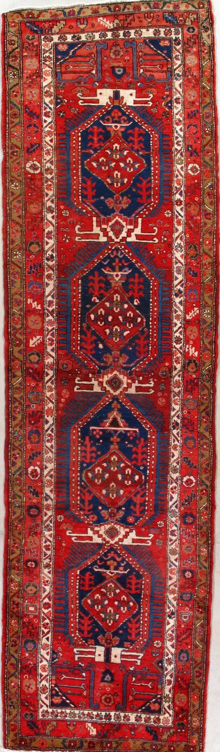 A red rug with a blue border on a white background.