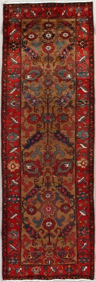 A red and brown rug with a floral pattern on it.