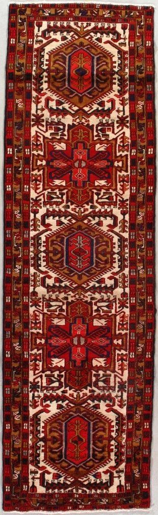 A red and white rug with a pattern on it is hanging on a wall.