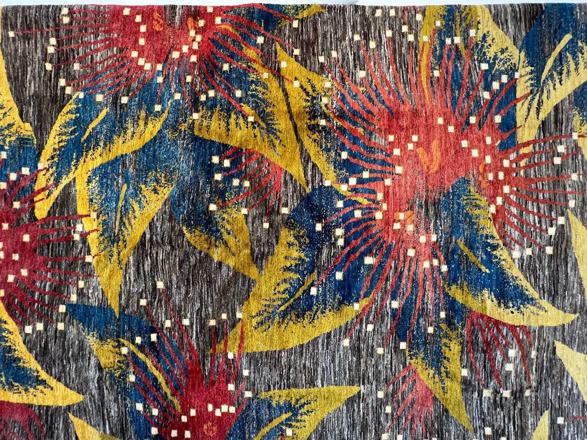 A dog is laying on a couch in front of a colorful wall.