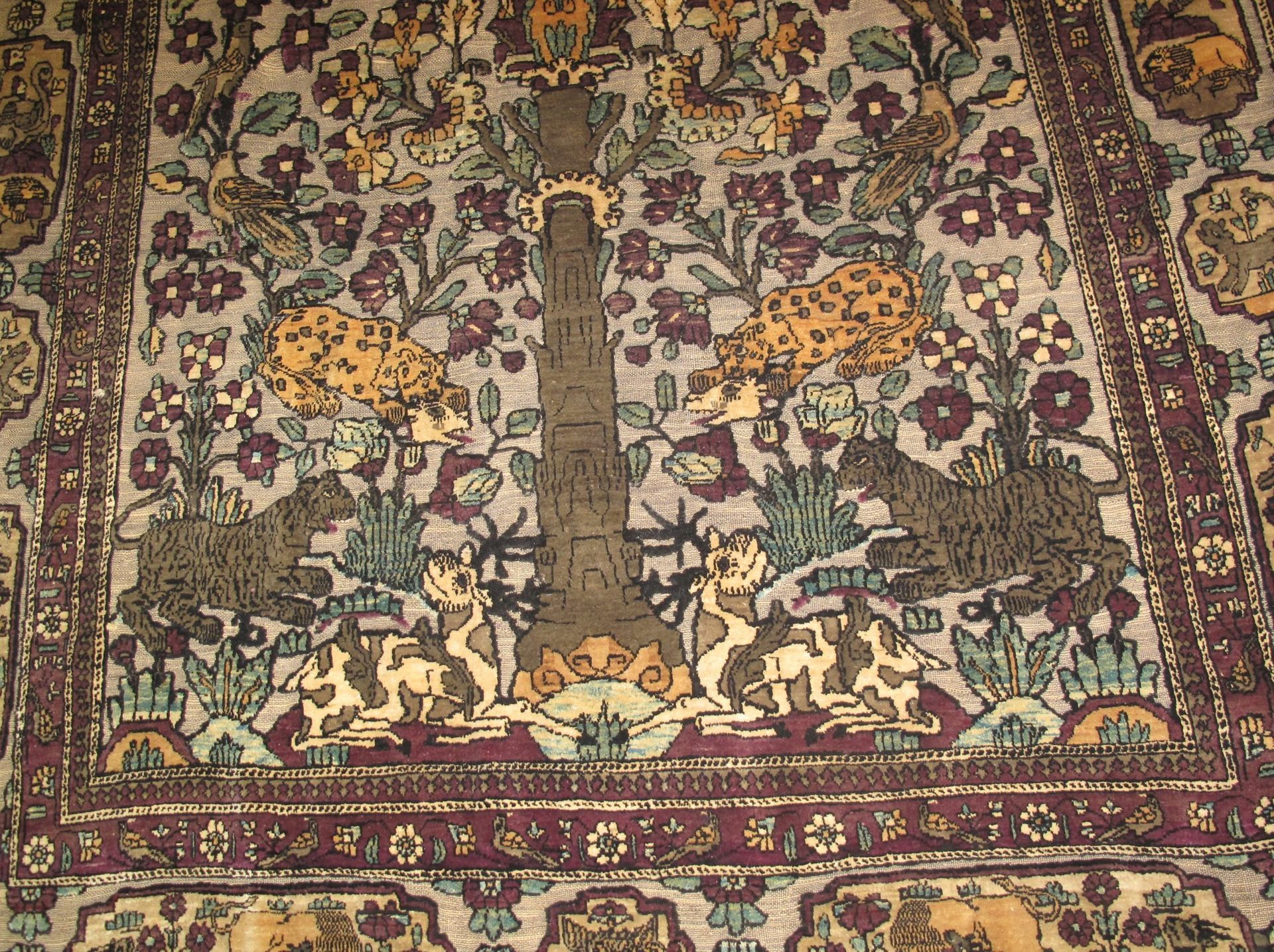 A rug with a floral pattern and elephants on it