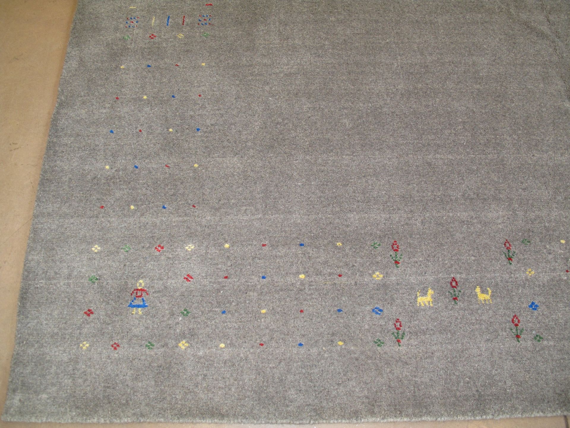 A gray rug is laying on a wooden floor